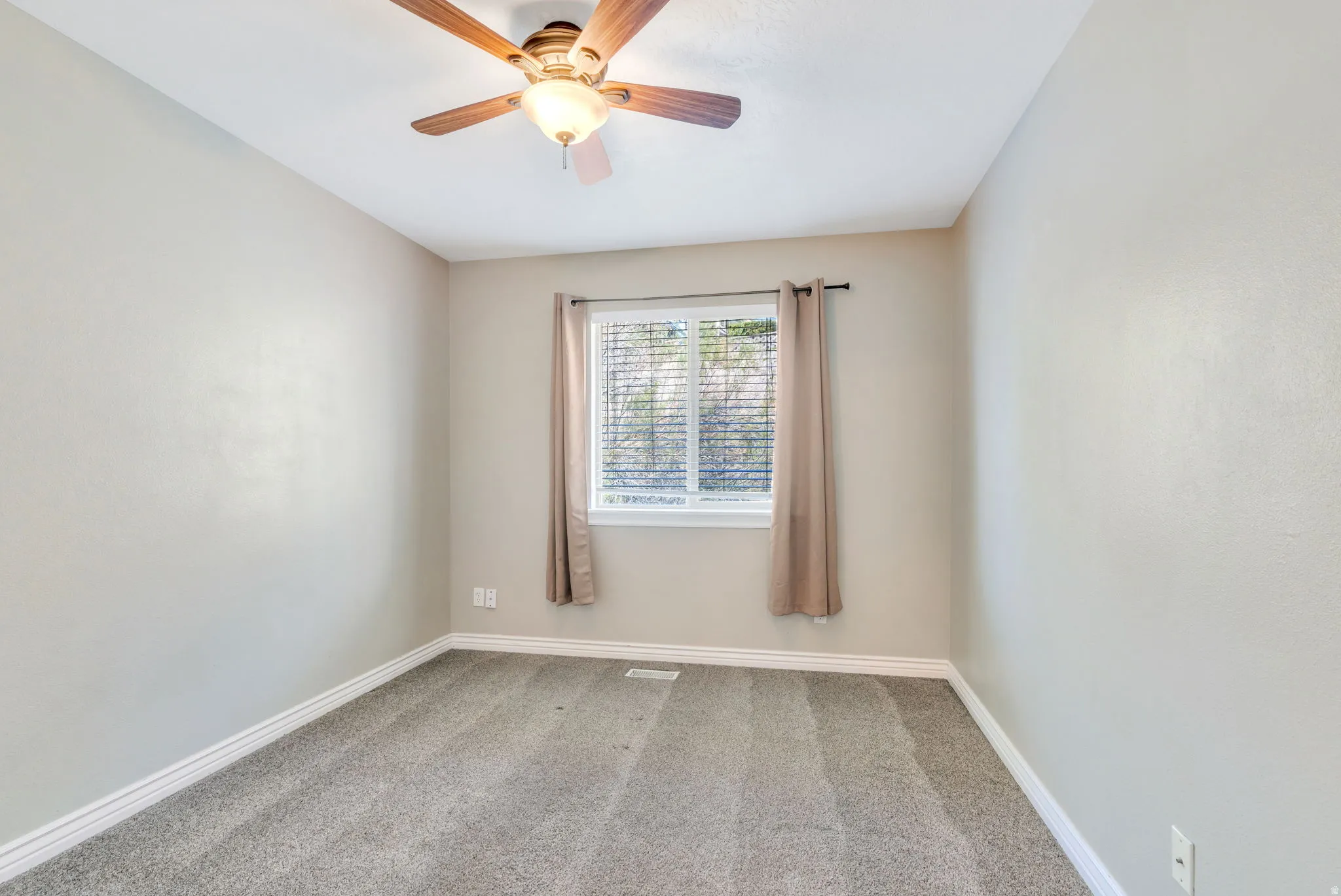 Spare room with light carpet and ceiling fan