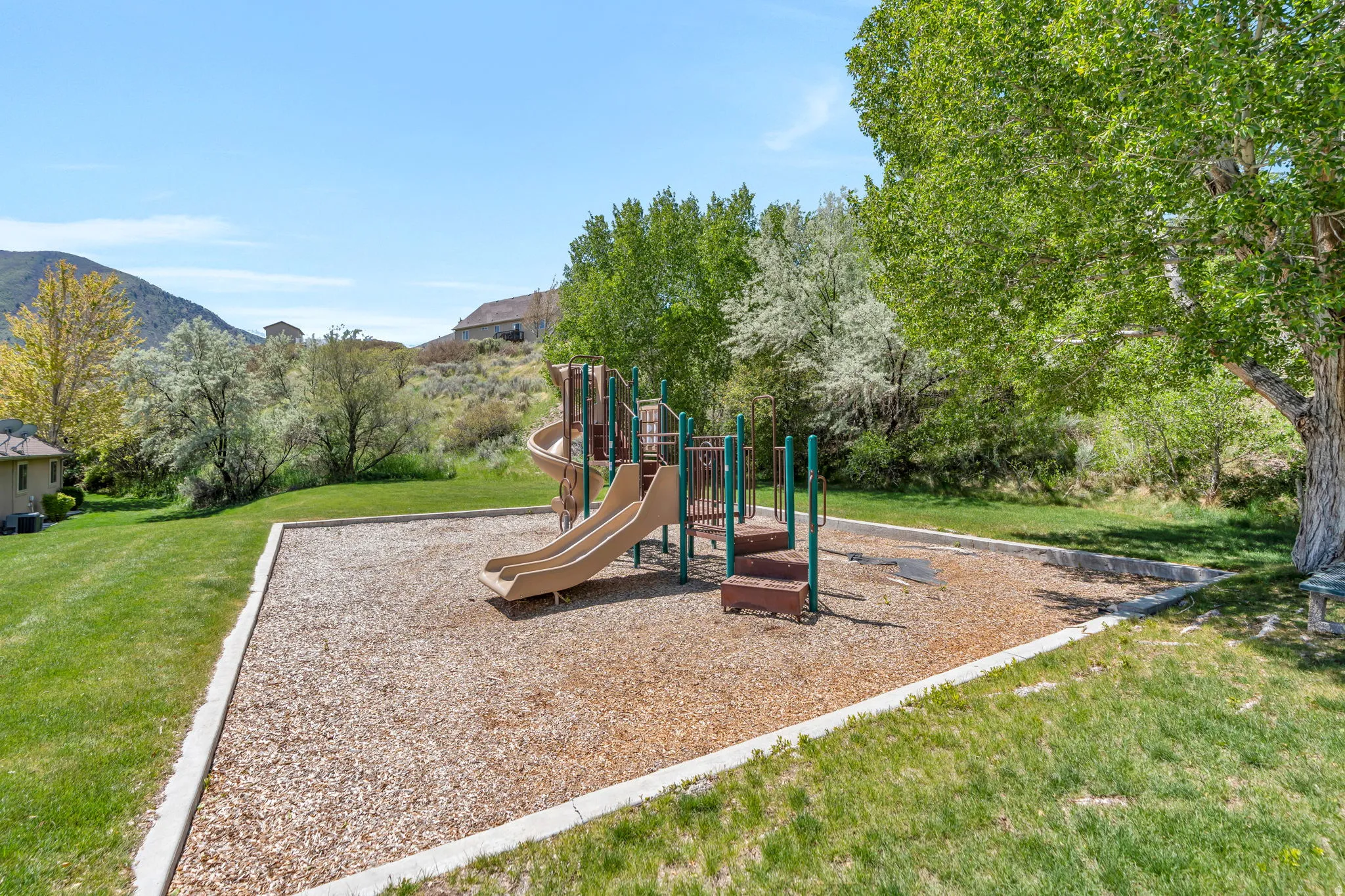 Community play area featuring a yard and a mountain view
