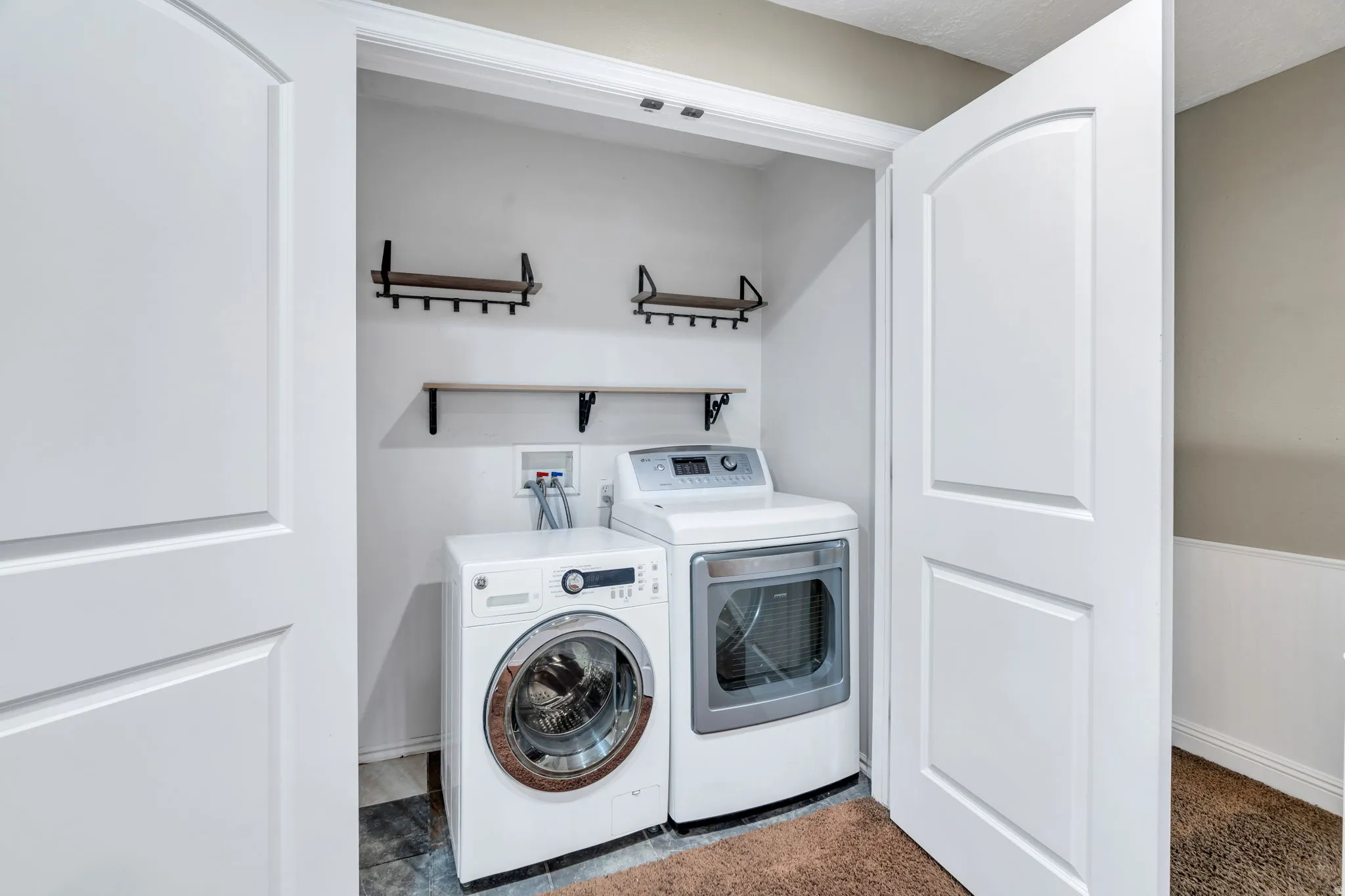 Laundry area with washer and clothes dryer and wainscoting