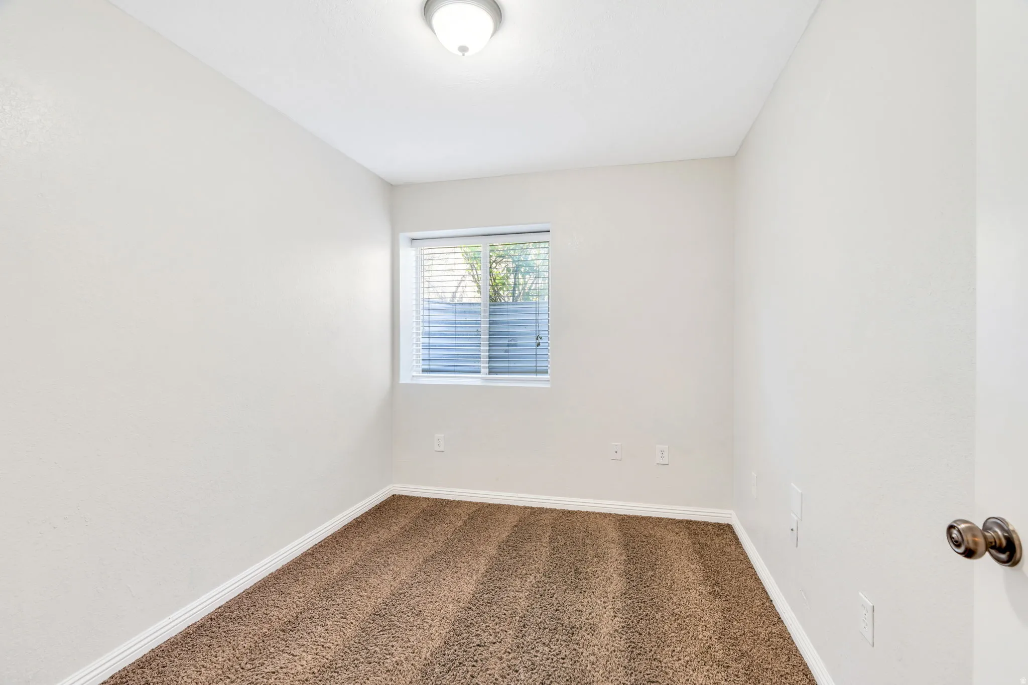 Empty room with baseboards and dark colored carpet