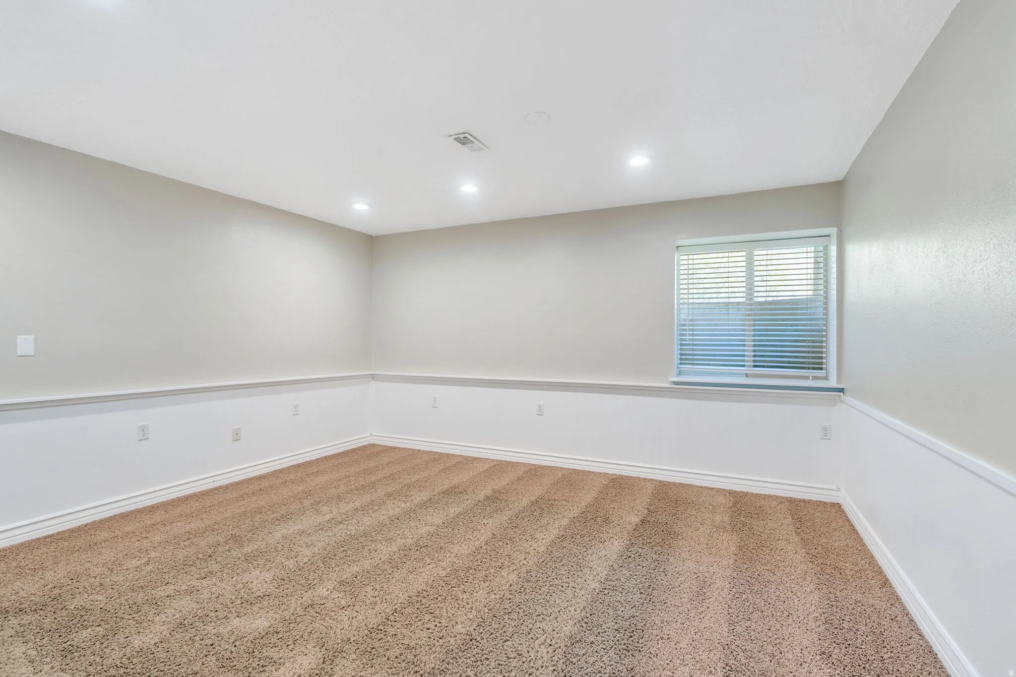 Spare room with carpet flooring, wainscoting, and recessed lighting