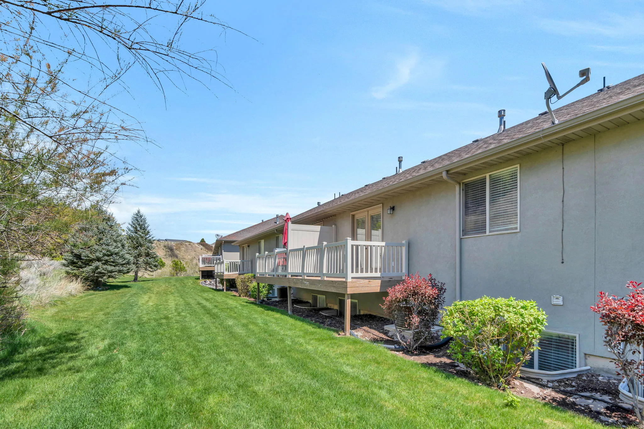 View of green lawn featuring a deck