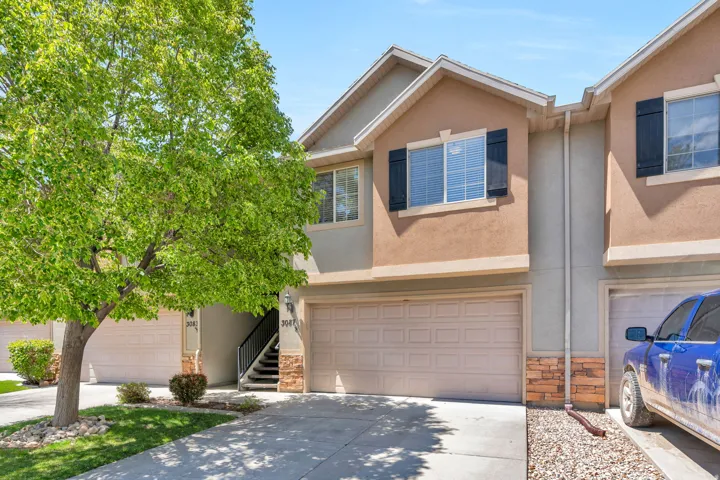 View of front of property with stone siding, stucco siding, an attached garage, and concrete driveway