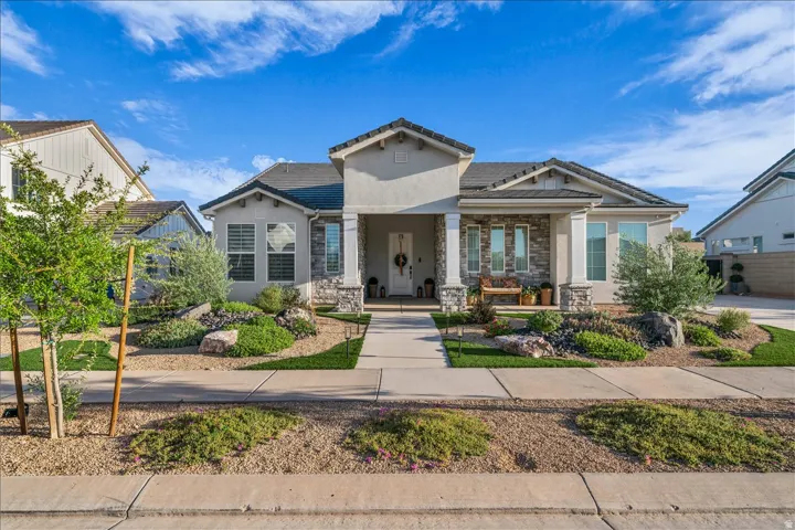 View of front of property with a porch, stone siding, and stucco siding