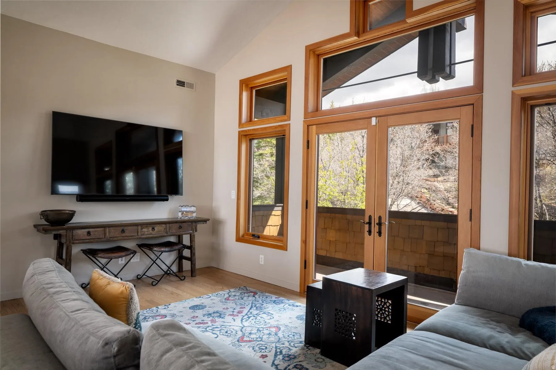 Living area featuring french doors, wood finished floors, and vaulted ceiling