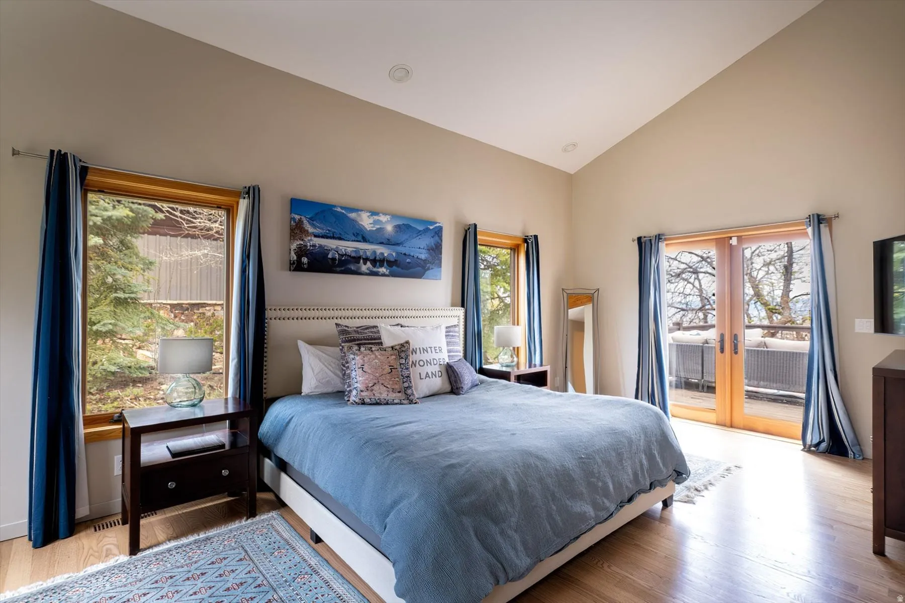 Bedroom featuring vaulted ceiling, light wood finished floors, french doors, and access to exterior