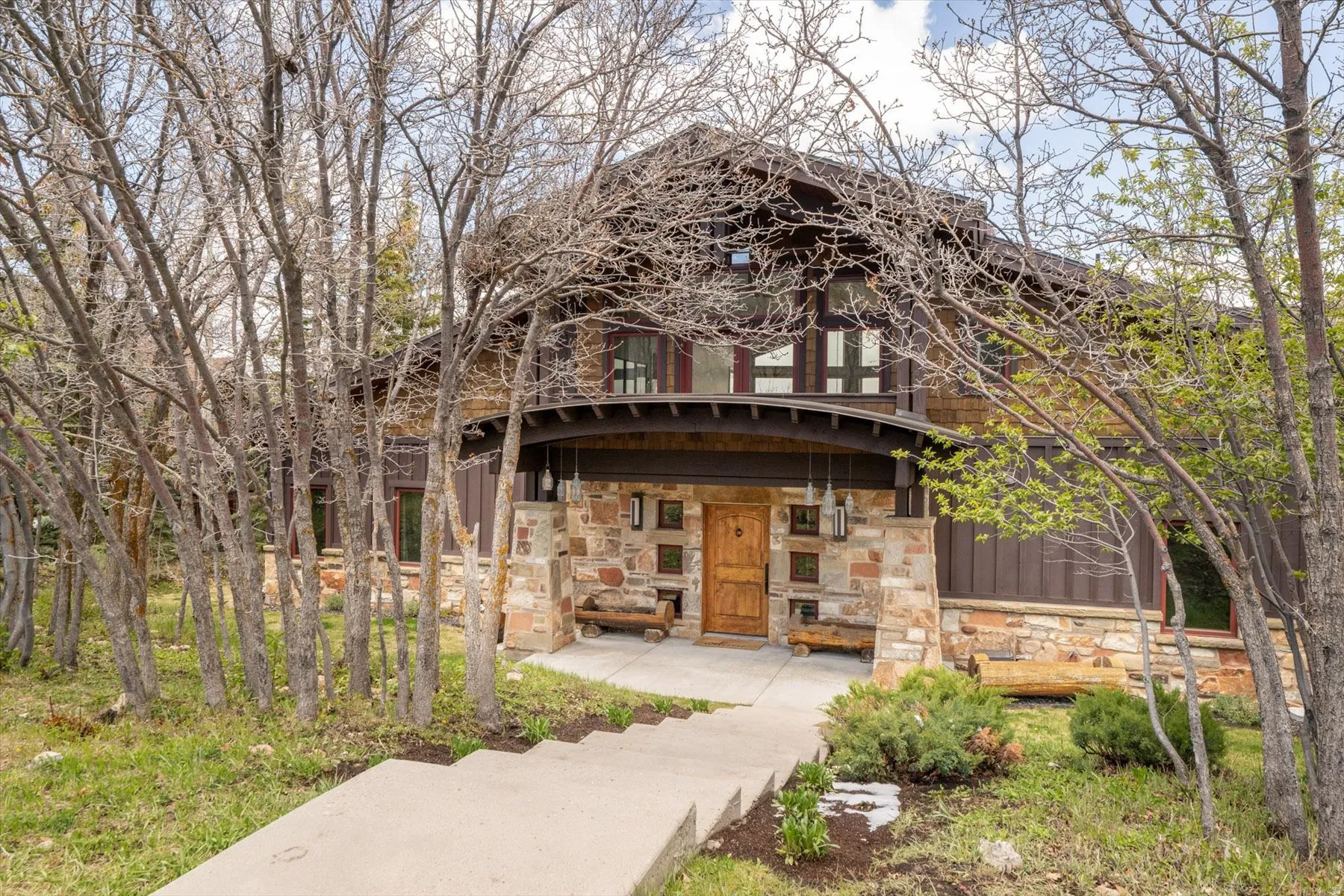 View of front of home featuring stone siding and covered porch