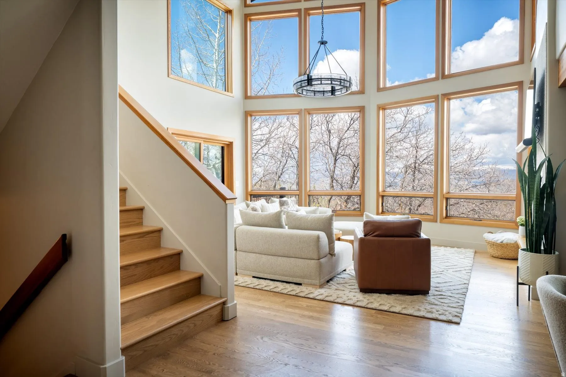 Living area featuring healthy amount of natural light, a high ceiling, and wood finished floors