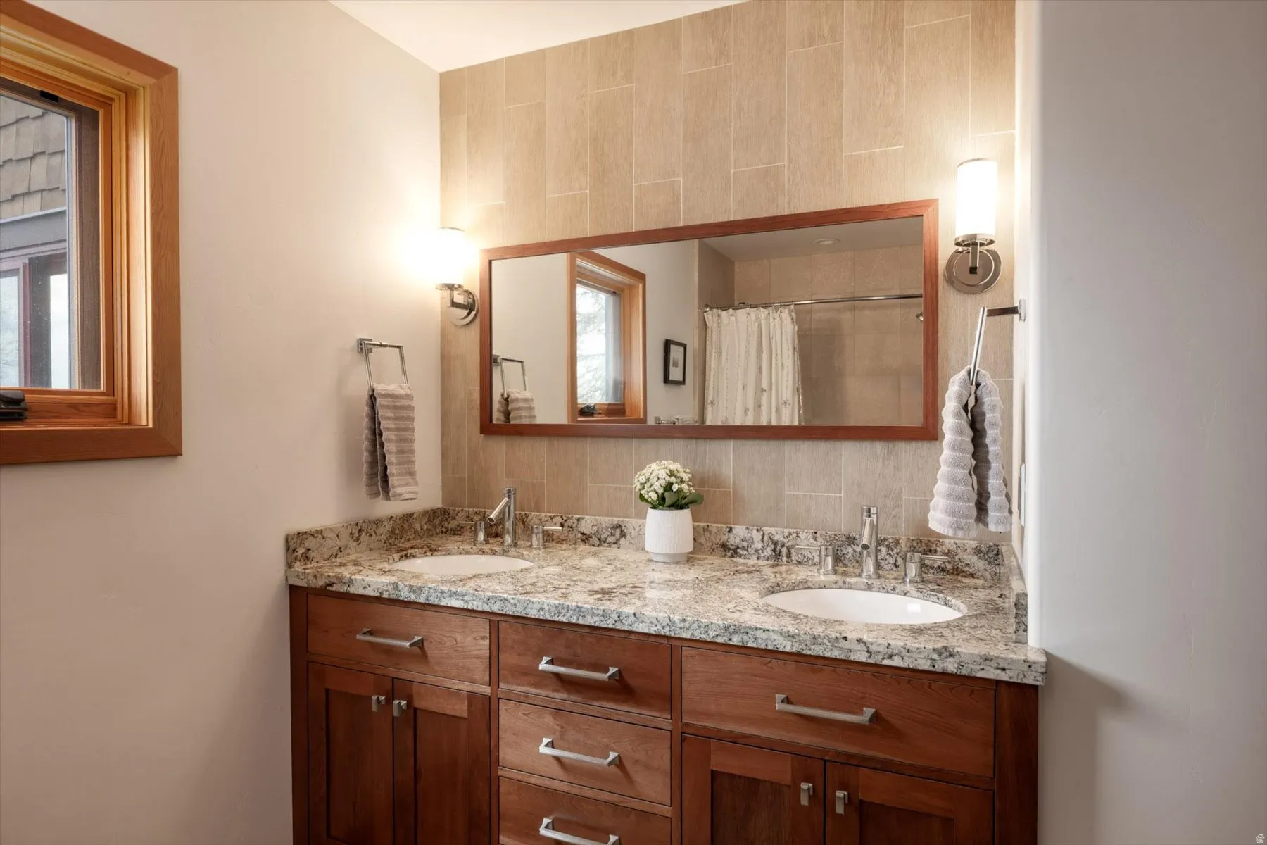 Full bath with double vanity, tasteful backsplash, and a shower with curtain