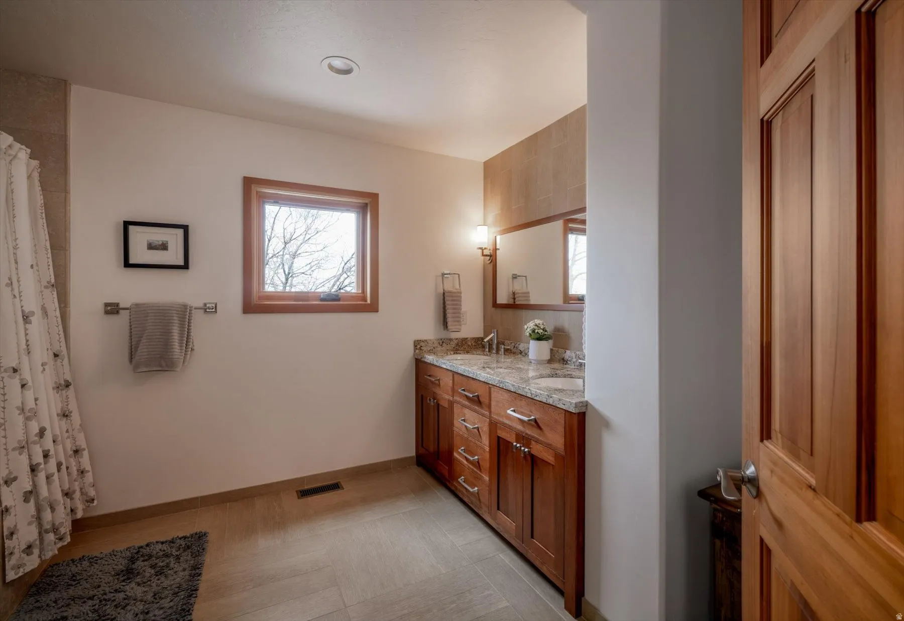 Bathroom featuring double vanity and curtained shower