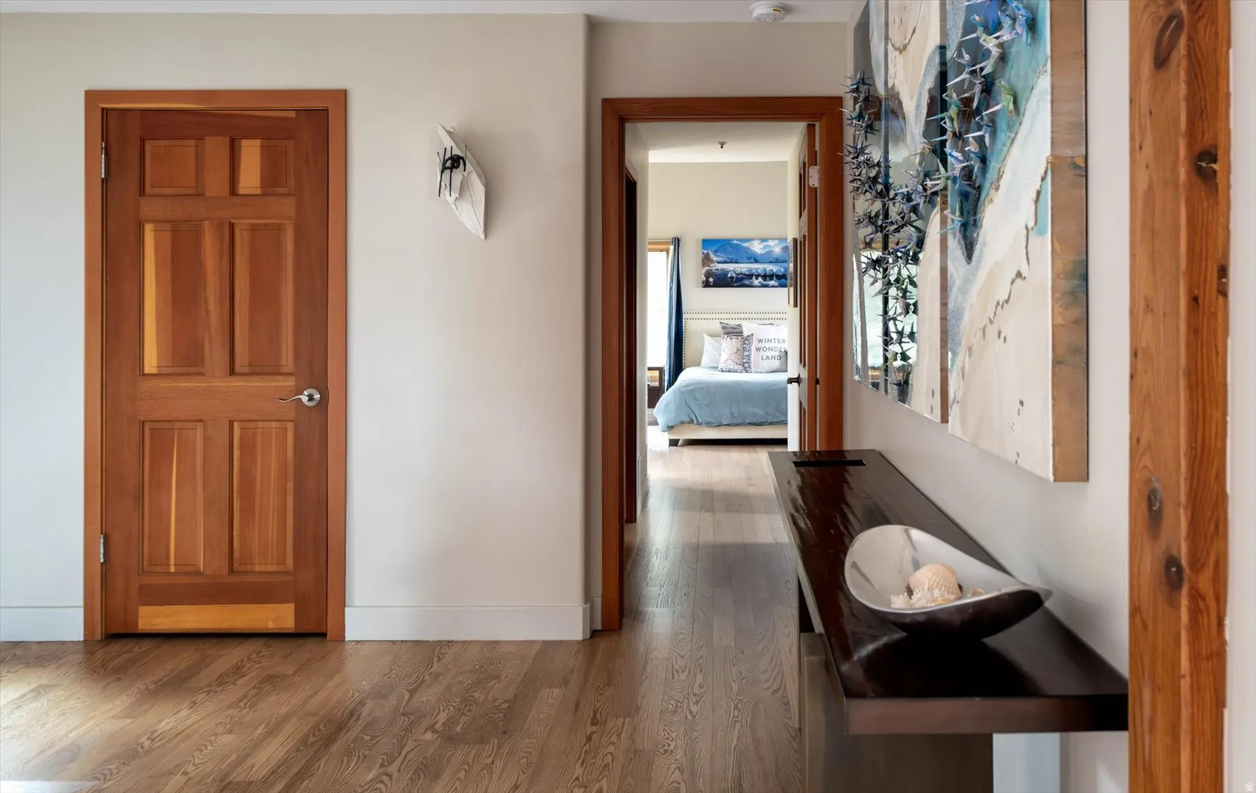 Corridor featuring dark wood-style floors and baseboards