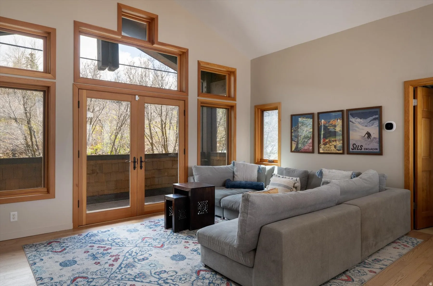 Living room featuring light wood-style floors, lofted ceiling, and french doors