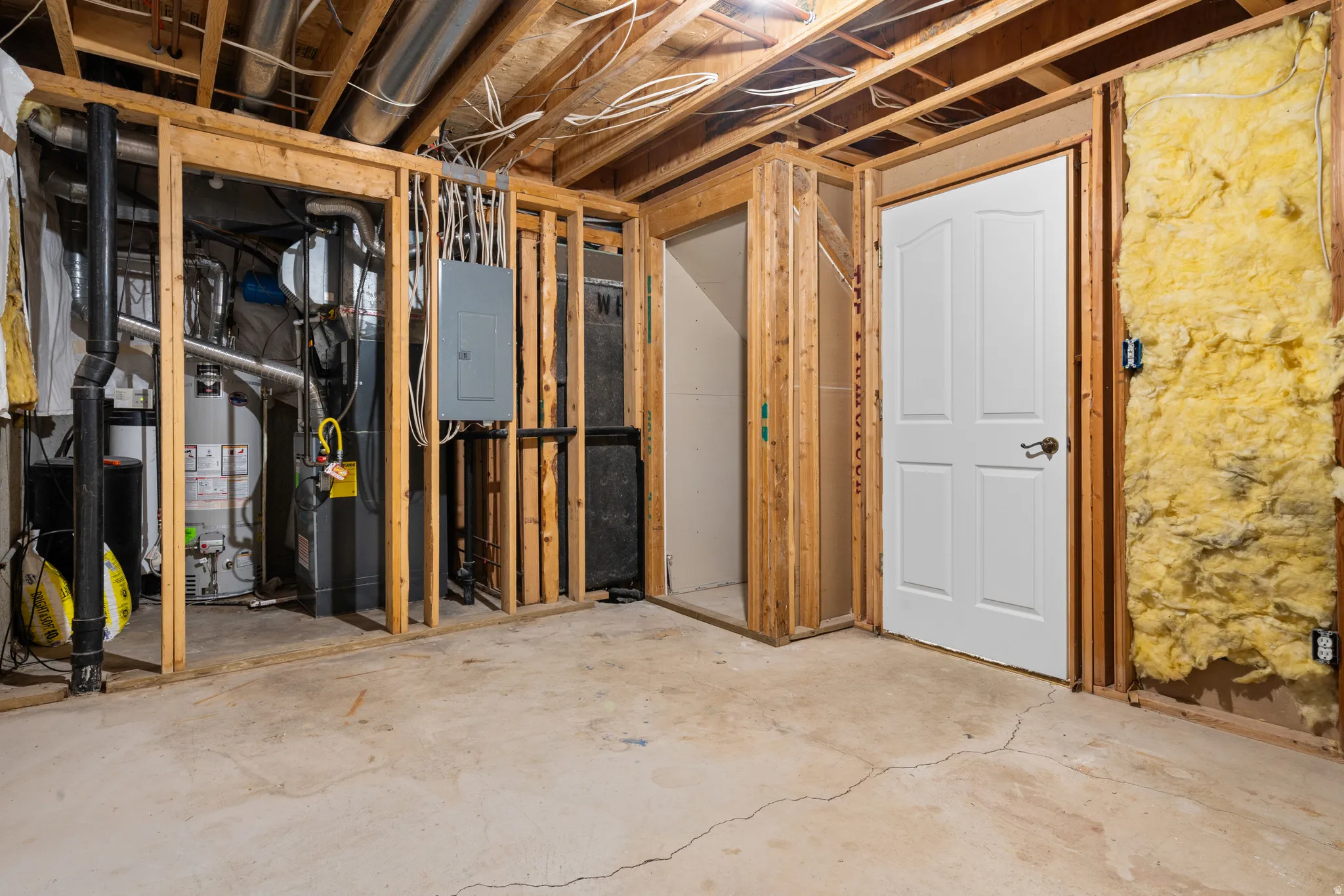 Below grade area featuring electric panel and water heater