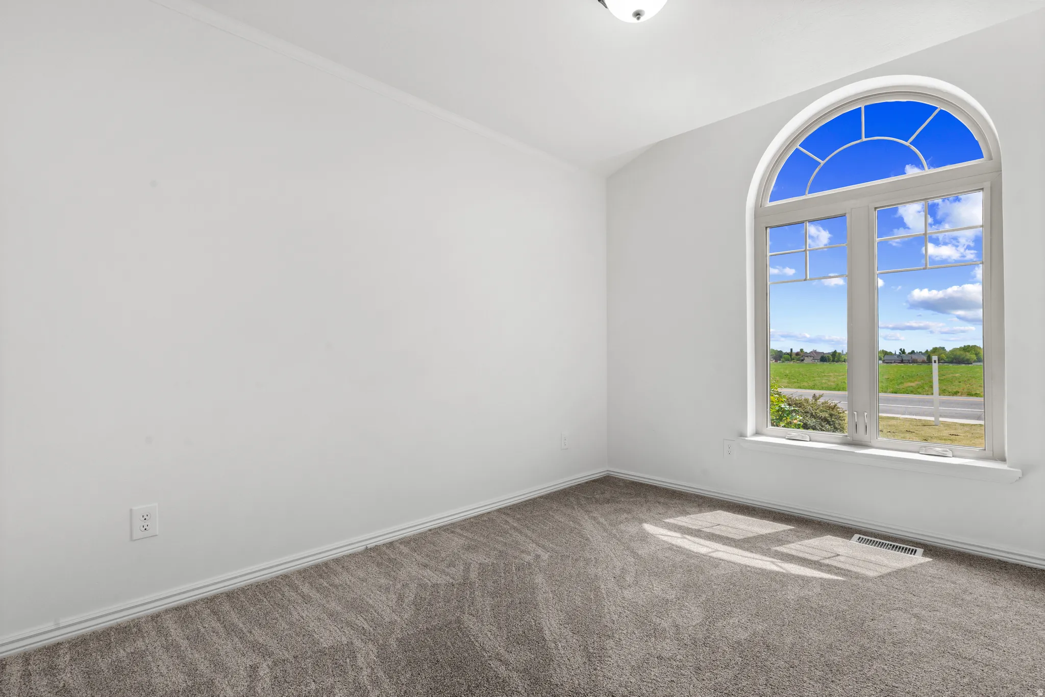Spare room featuring carpet and baseboards