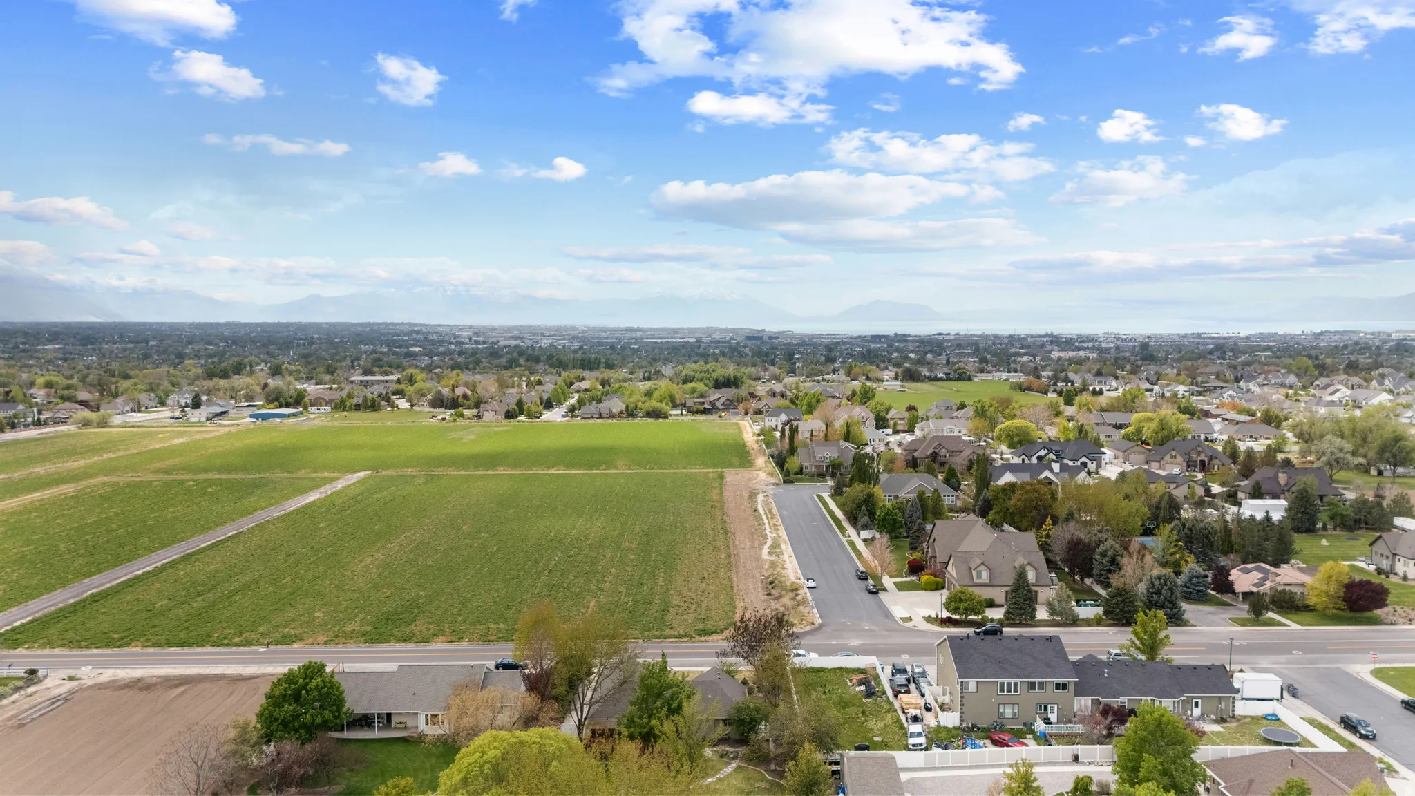 Aerial view of residential area featuring extensive farmland
