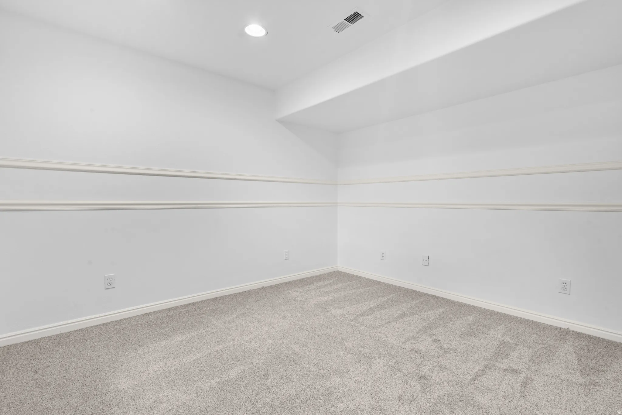 Empty room featuring light carpet and recessed lighting