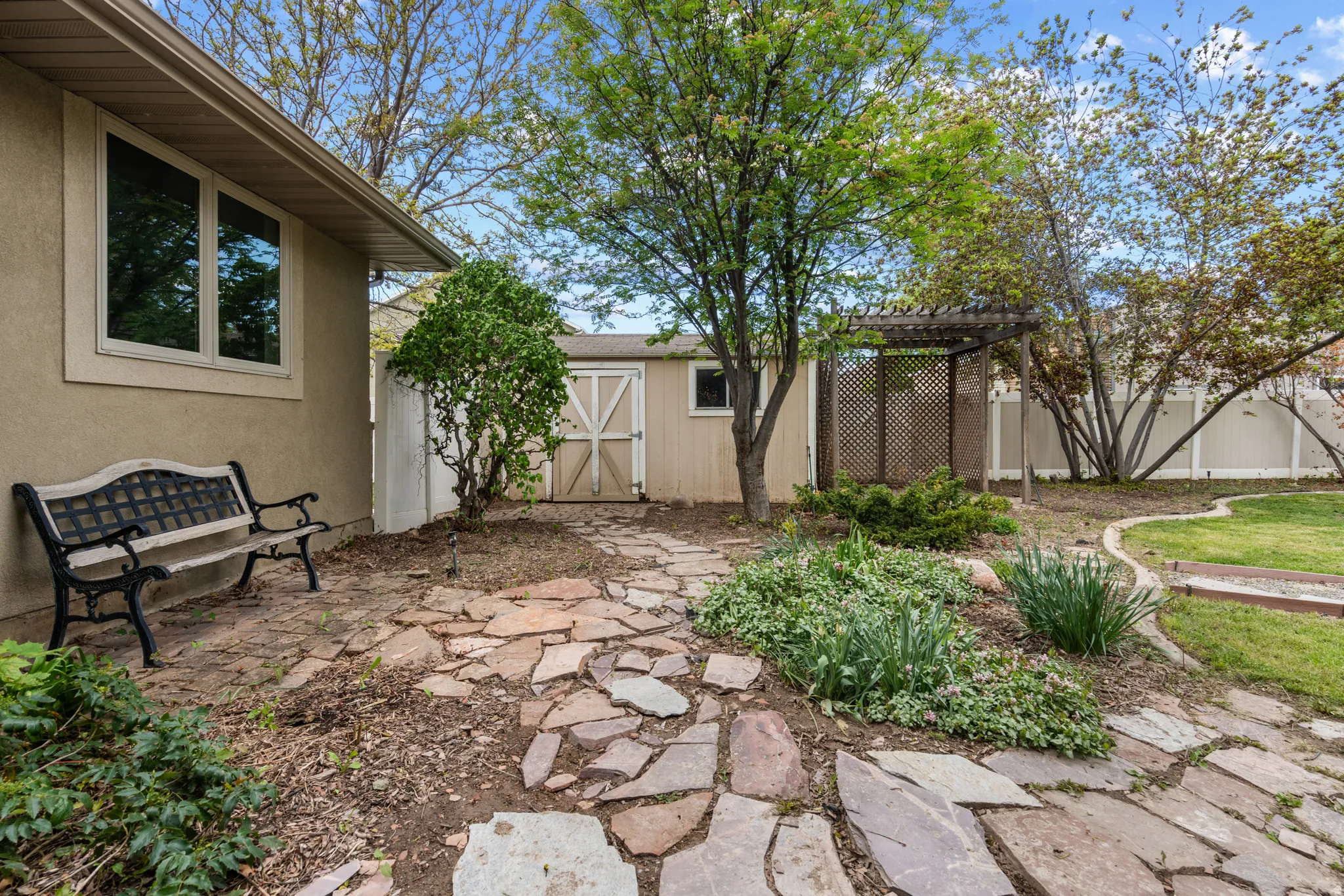 Fenced backyard featuring a patio, a storage unit, and a pergola