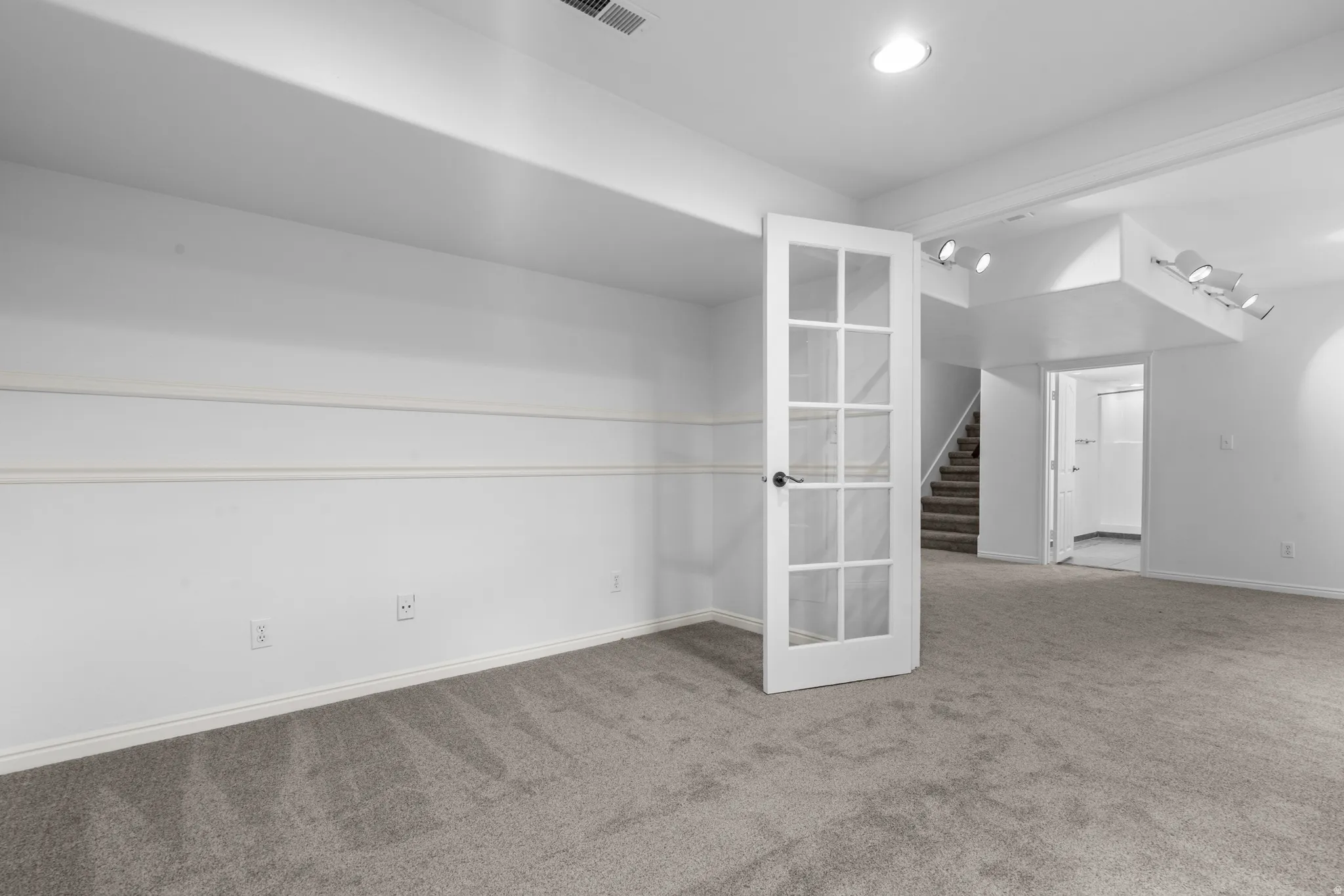 Spare room with stairs and carpet