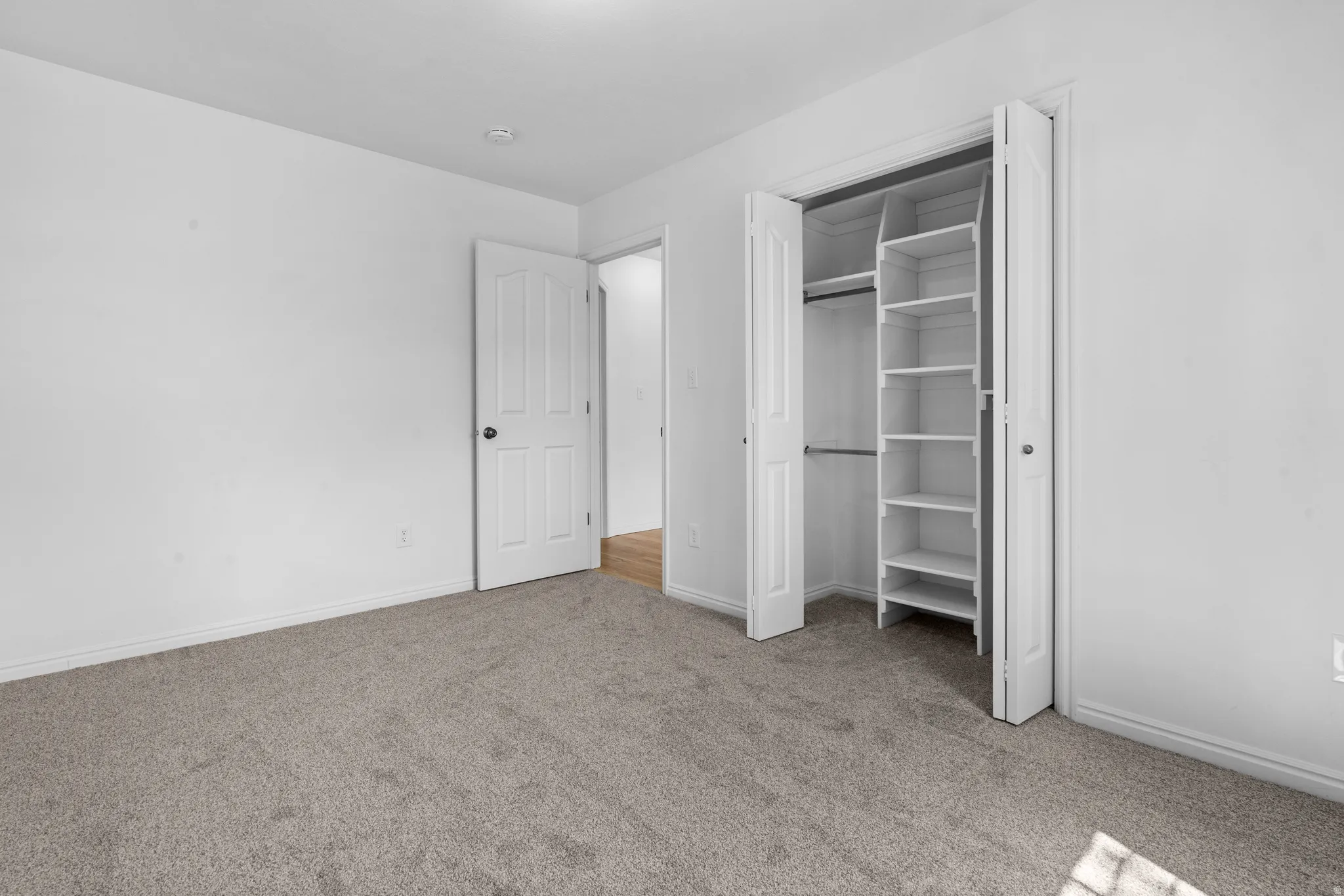 Unfurnished bedroom featuring light carpet and a closet