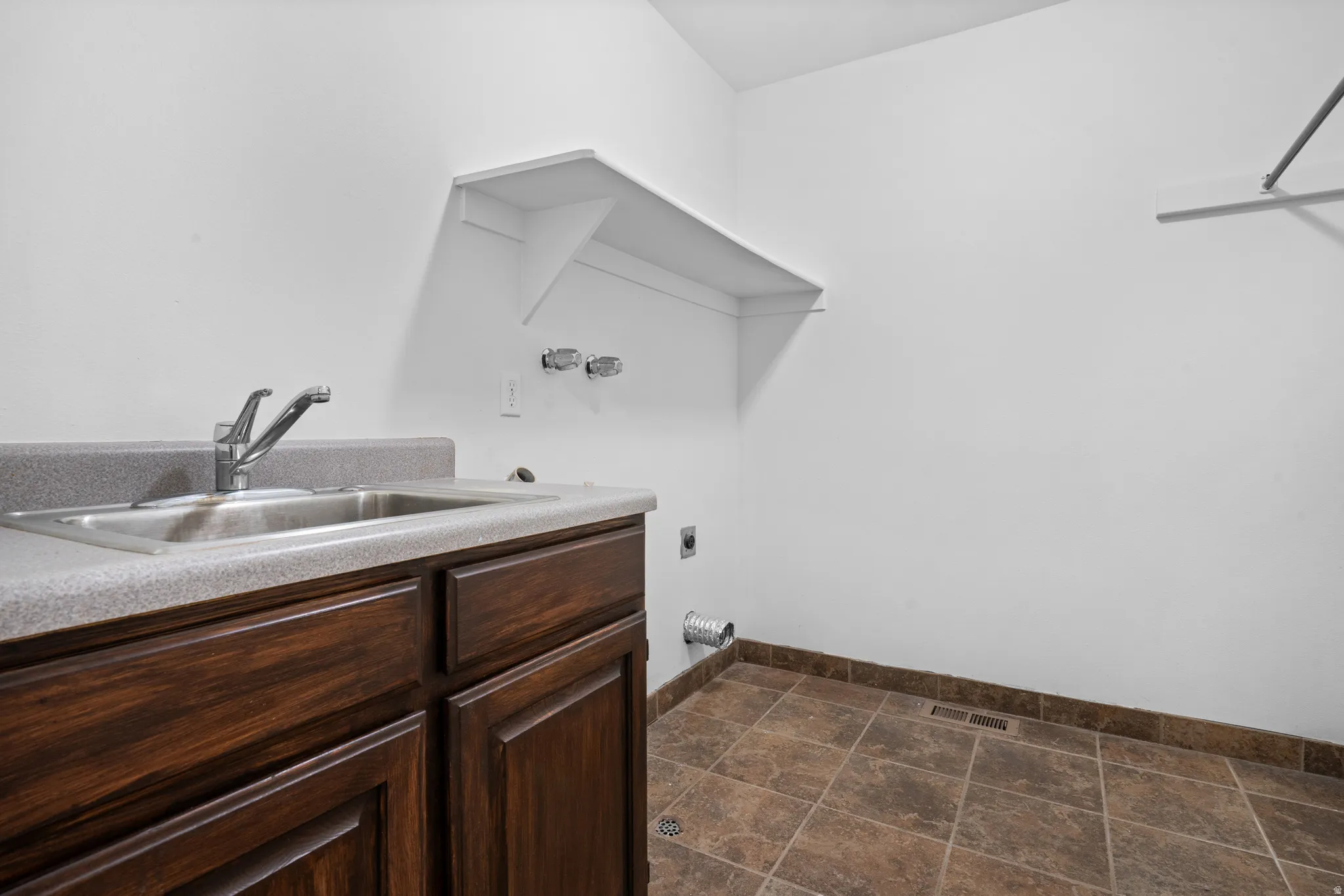 Laundry area featuring electric dryer hookup and cabinet space