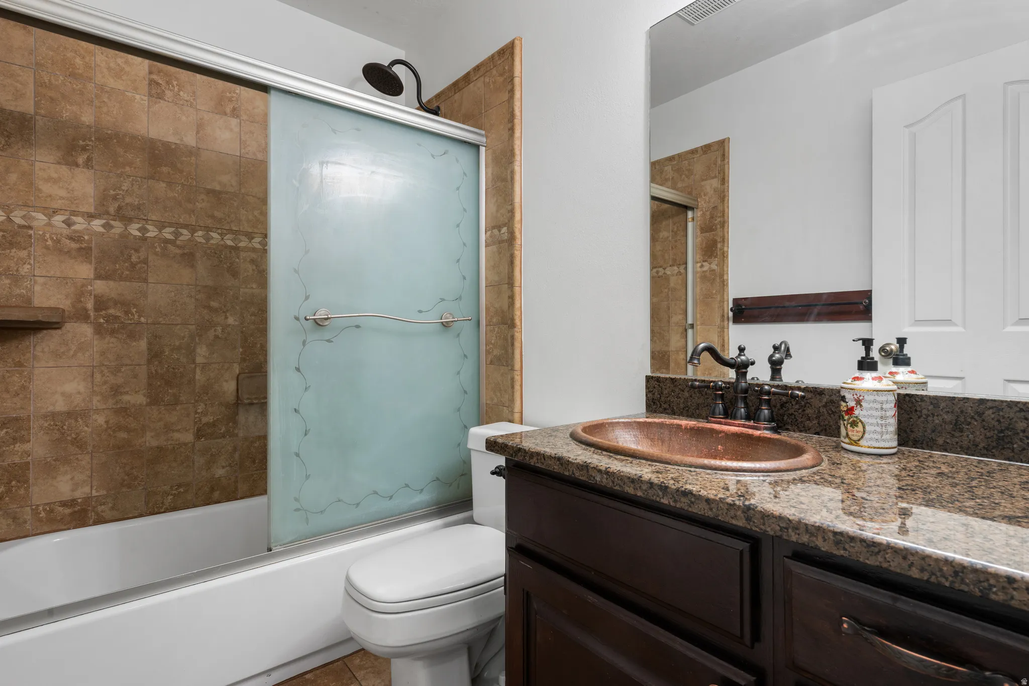 Full bath featuring vanity and bath / shower combo with glass door