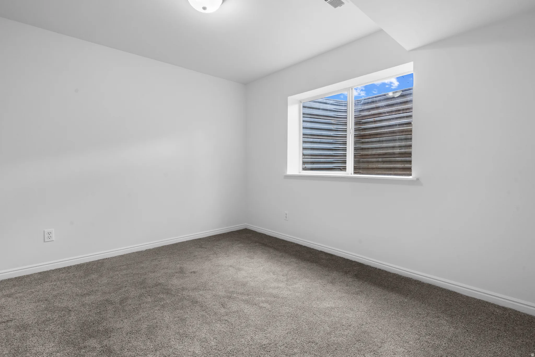 Carpeted empty room featuring baseboards