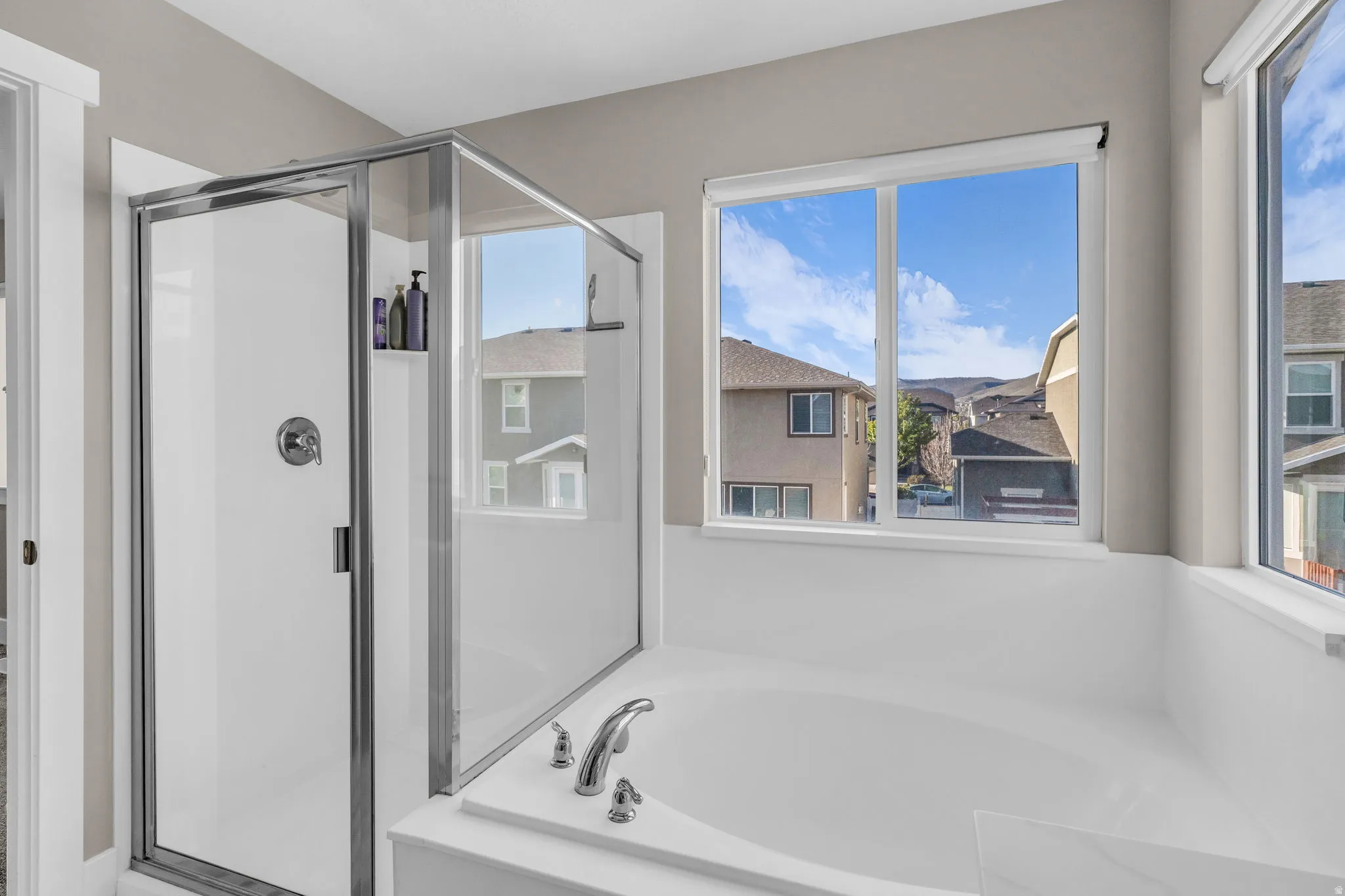 Full bathroom featuring a shower stall and a bath
