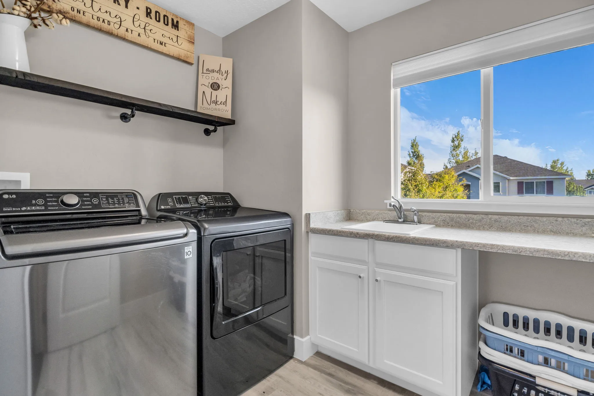 Laundry area featuring washing machine and clothes dryer and light wood-type flooring