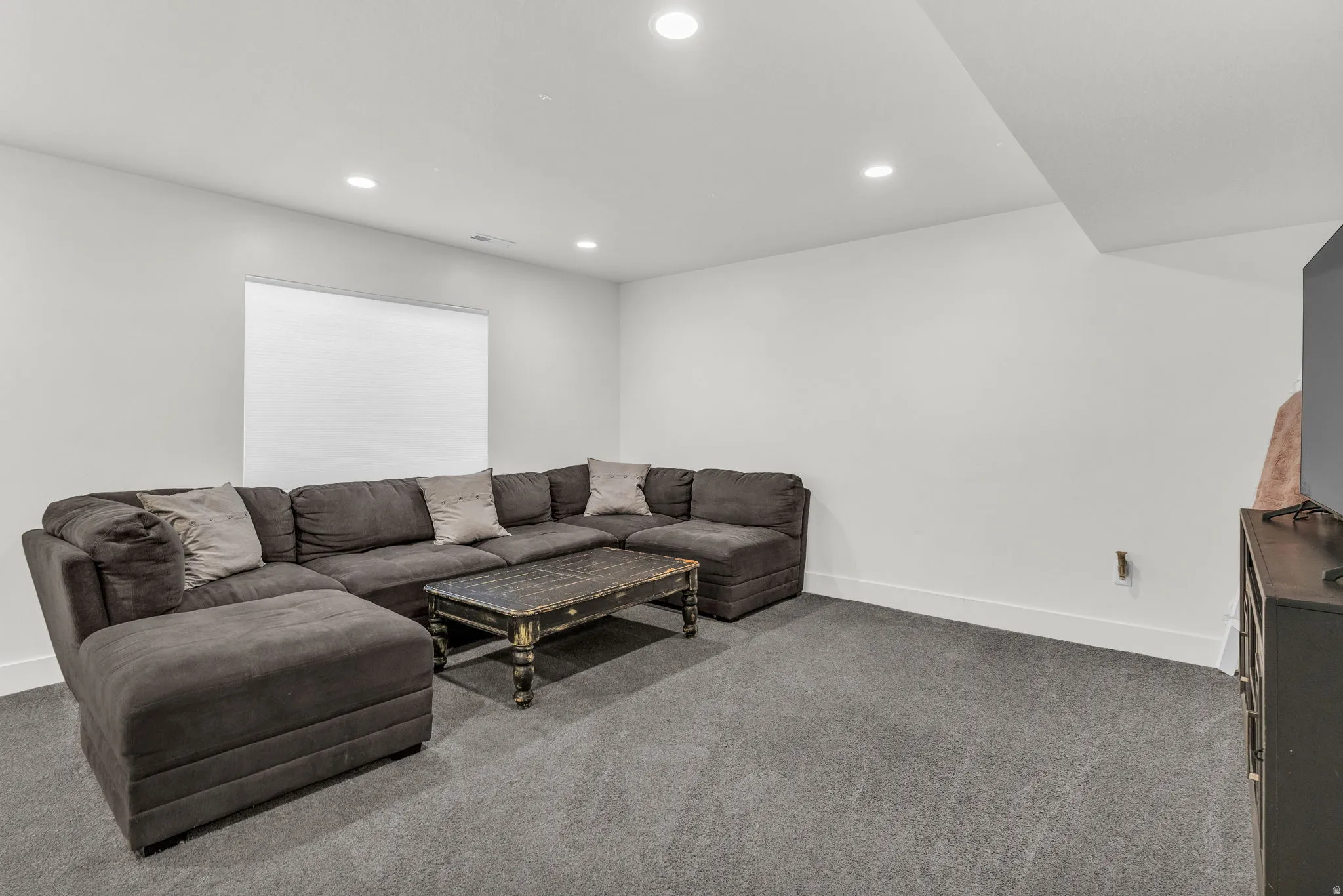Carpeted living room featuring recessed lighting and baseboards
