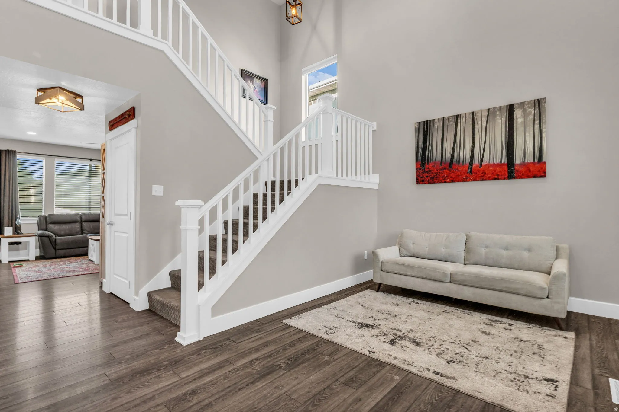 Living area with a high ceiling and dark wood finished floors