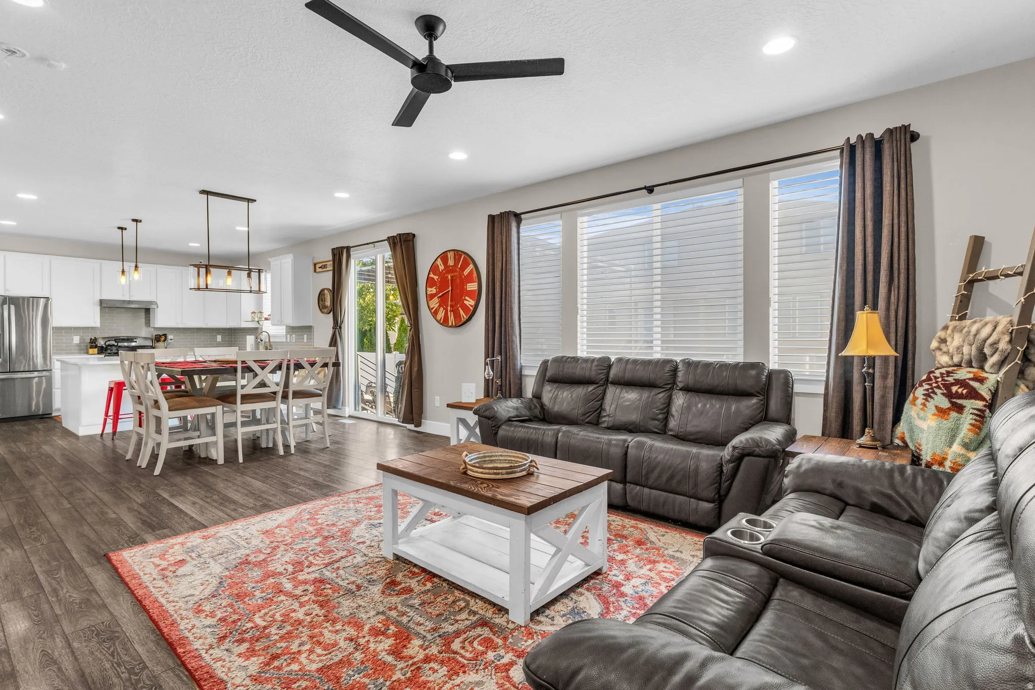 Living room with dark wood finished floors, a ceiling fan, recessed lighting, and a textured ceiling