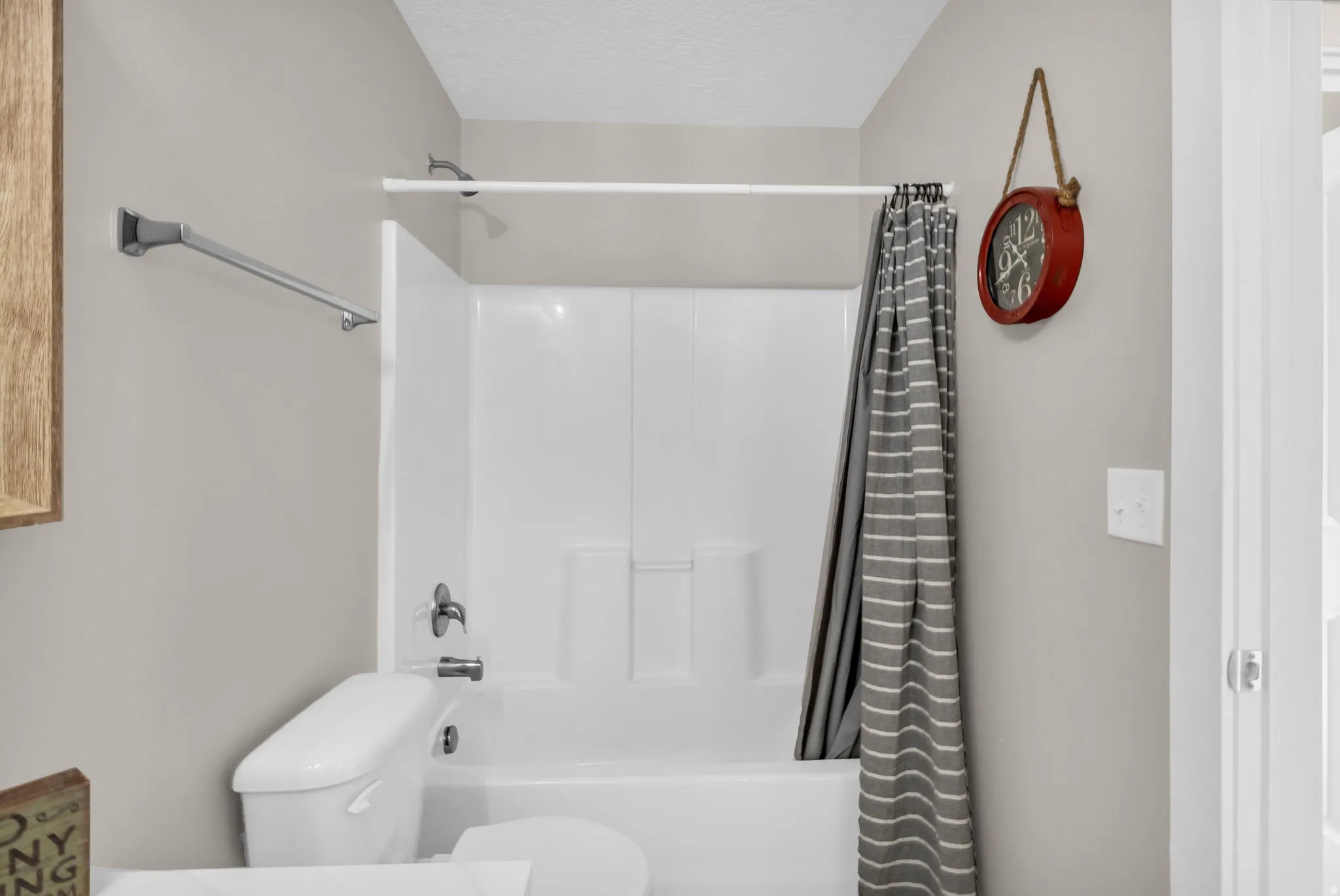 Bathroom with shower / bath combo, a textured ceiling, and vanity