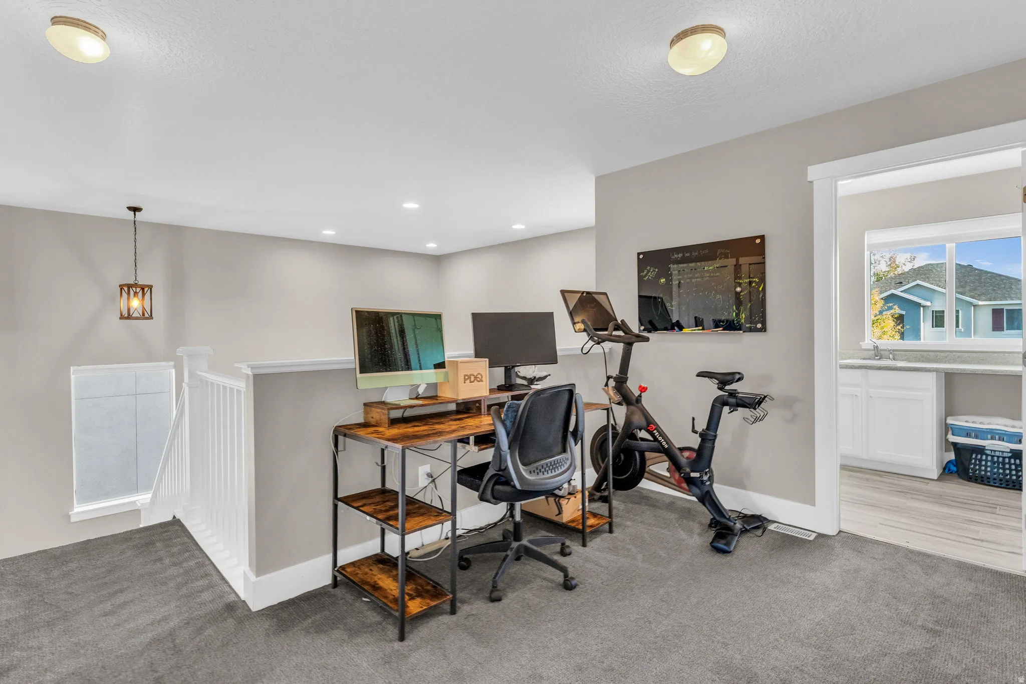 Home office with light colored carpet and baseboards