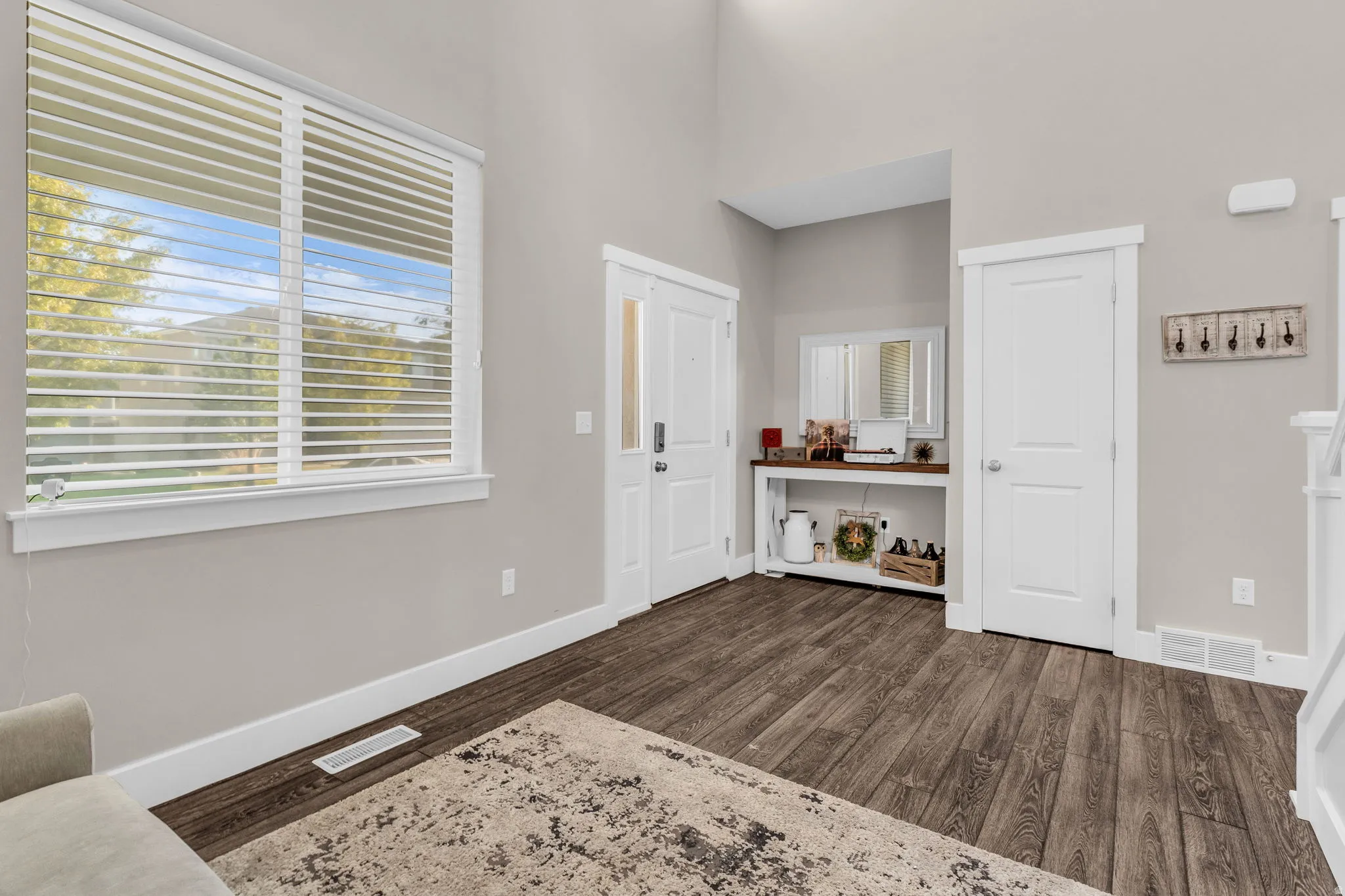 Entrance foyer with dark wood-style floors and a high ceiling