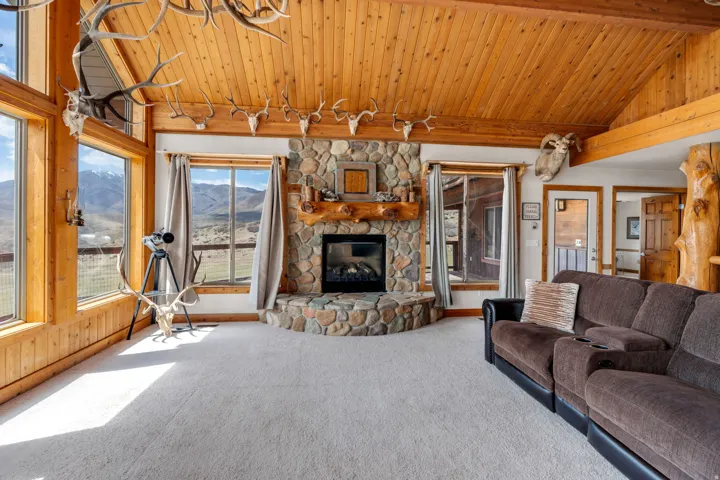 Carpeted living area featuring a vaulted wood ceiling, a mountain view, and a fireplace