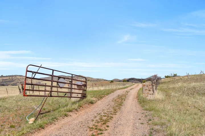 View of dirt / gravel road with a rural view and a mountain view