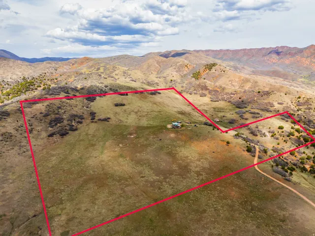 Overview of rural landscape with a mountain backdrop and property parcel outlined