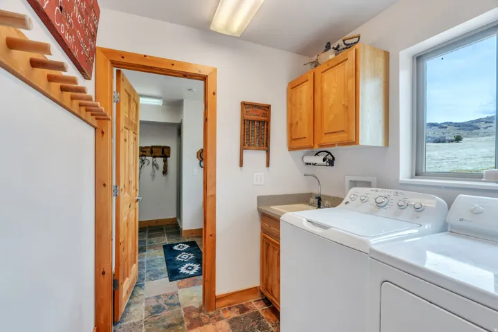 Laundry room featuring dark stone finish floors, cabinet space, and separate washer and dryer