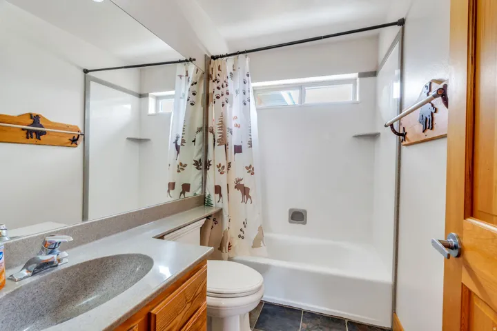 Bathroom featuring vanity and shower / bath combination with curtain