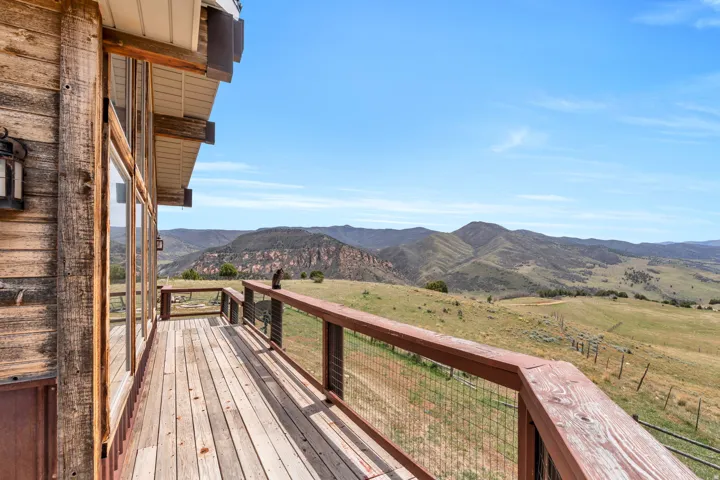 Wooden terrace featuring a mountain view and a view of countryside