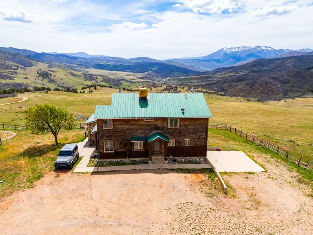 View of front of house featuring a metal roof, a view of countryside, a chimney, and a mountain view
