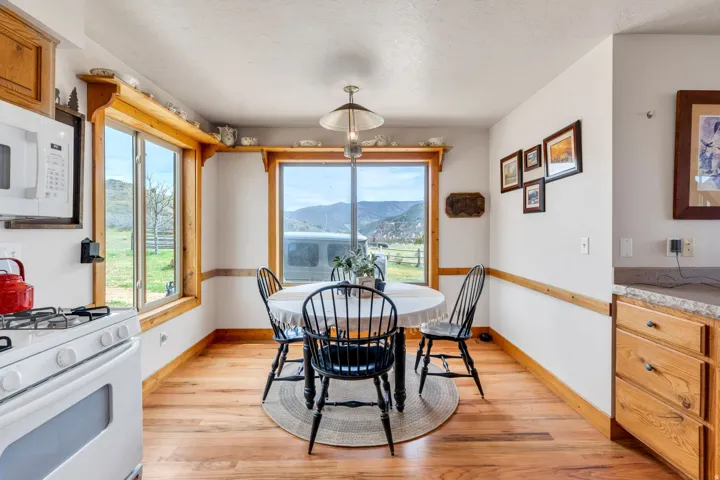 Dining room featuring a mountain view, light wood-style flooring, and a textured ceiling
