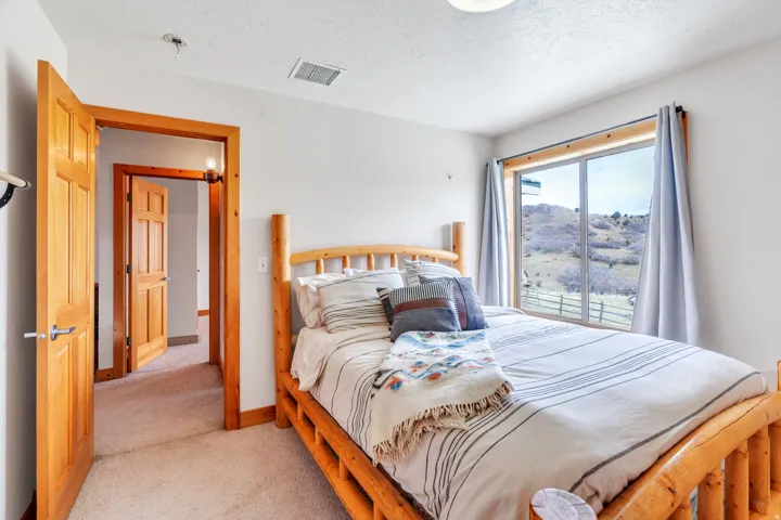 Bedroom featuring light carpet, a mountain view, and a textured ceiling