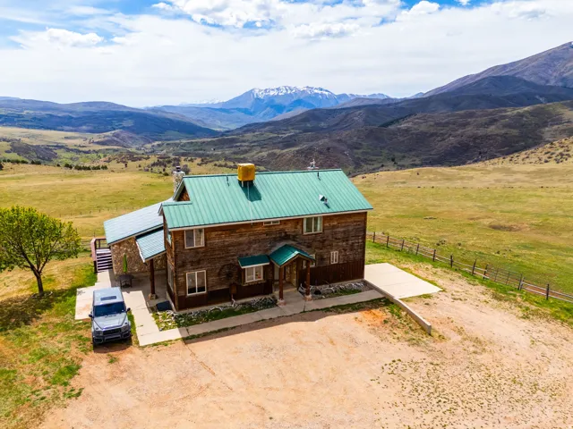 View of front of home featuring a chimney, a metal roof, a rural view, and a mountain view