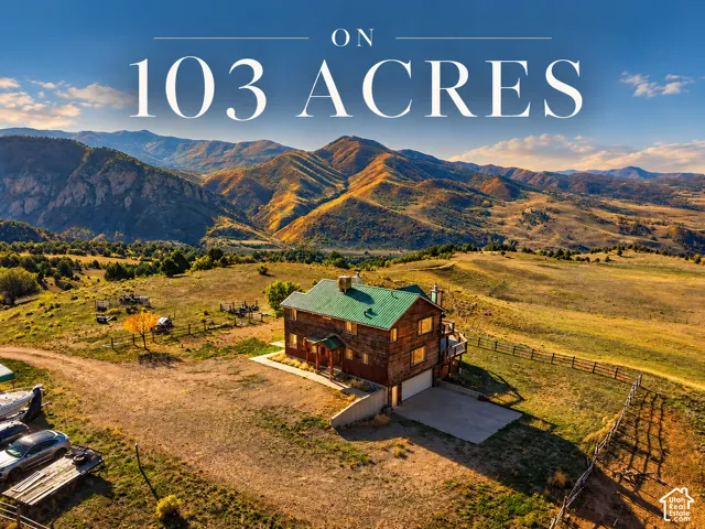 Expansive 103-acre property featuring a multi-story residence with a metal roof, wood siding, and mountain backdrops