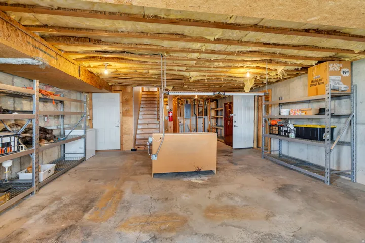 Unfinished basement featuring stairway and electric panel