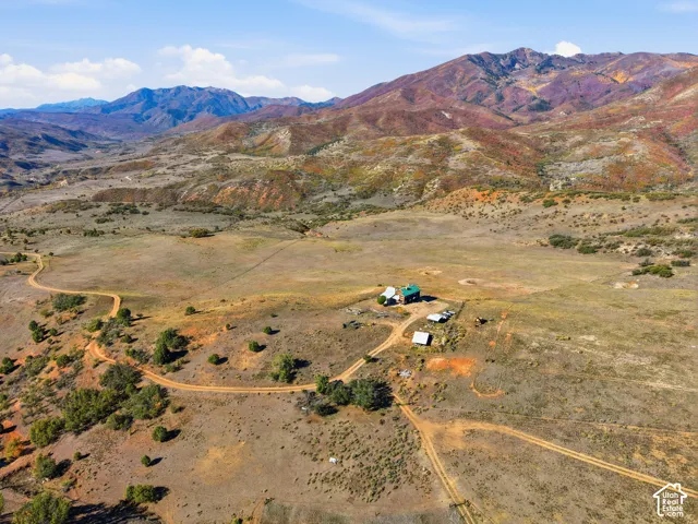 Aerial perspective of expansive acreage featuring native topography and prominent mountain range backdrop