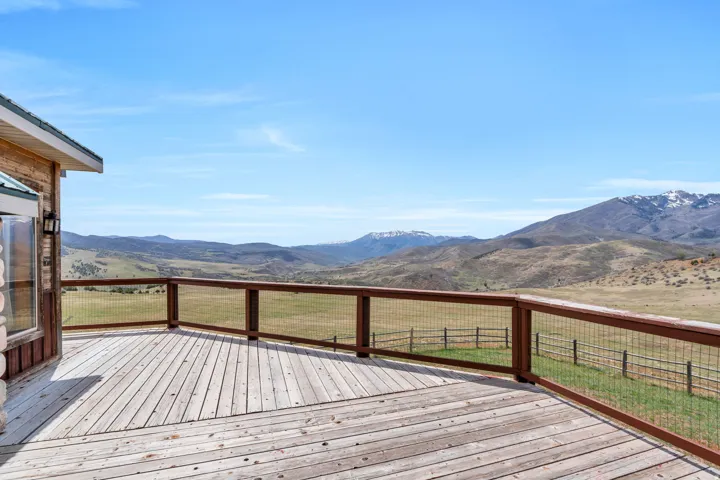 Wooden deck with a mountain view and a lawn