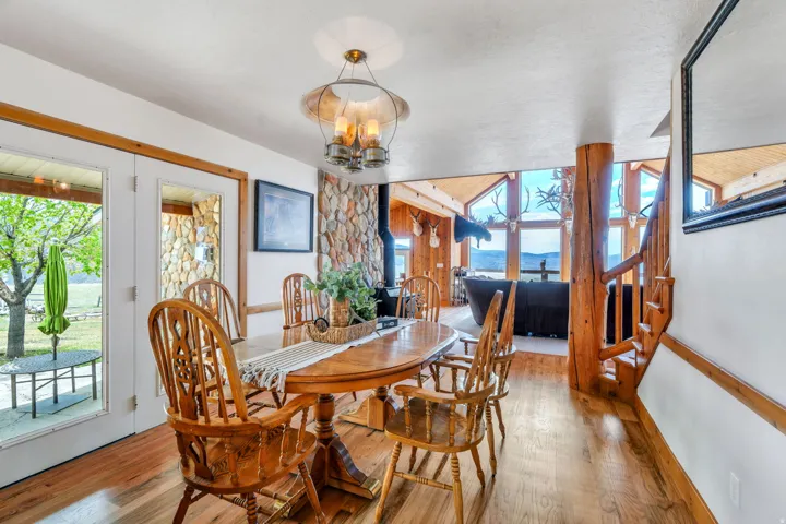 Dining area with a wood stove, light wood-type flooring, and hanging lights
