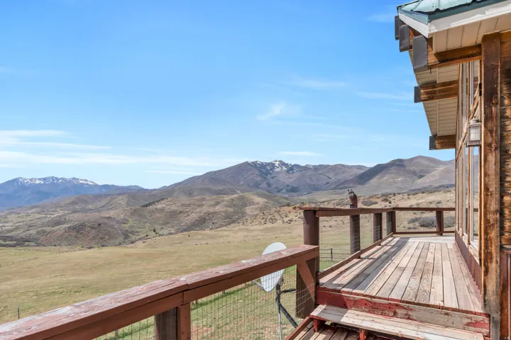 Wooden deck featuring a lawn, a mountain view, and a view of rural / pastoral area